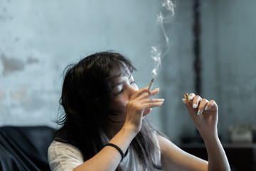 Asian girl smoking and feeling be absent-minded