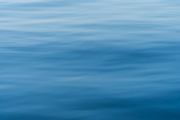 Naklejka premium Blur water surface as background. Calm water surface. Blue sea as texture.