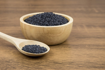 Black sesame seeds in a wooden spoon For healthy food and diet concepts.