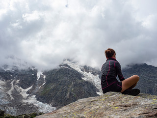 Naklejka na ściany i meble Woman standing on a rock in the italian alps