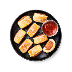 Delicious homemade sausage rolls on black plate isolated on white background