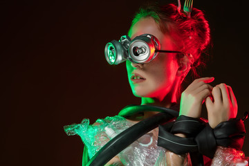 Portrait of upset girl with glasses of cans on eyes. Young woman is choking, bounded, wrapped,...