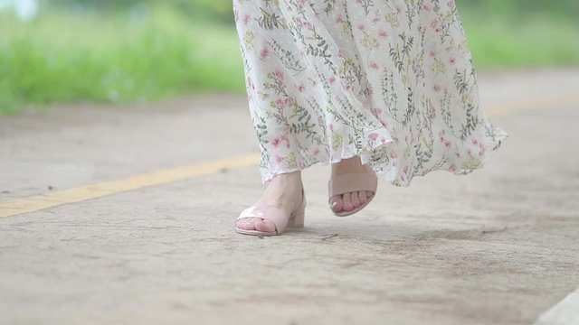 Close up Female feet walking ,the wind blowing her skirt