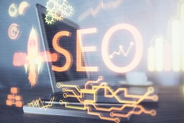Multi exposure of table with computer and seo drawing hologram. Search optimization concept.