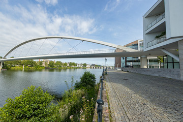 High bridge (Hoge Brug) over the Maas river, pedestrian sidewalk with pole lamps, St. Servatius bridge (Sint Servaasbrug) in the background, sunny day in Maastricht, South Limburg, Netherlands