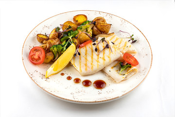 grilled squid with garnish. garnish fried potatoes with vegetables and lemon