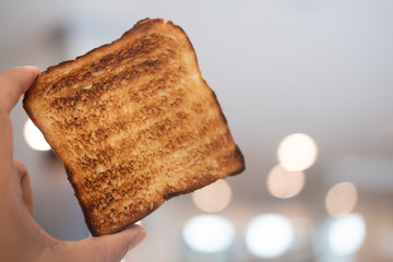 Man holding up a toast was burnt during toasting
