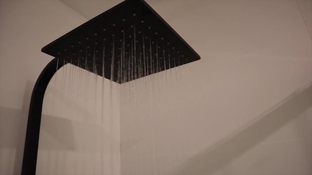 Finished bathroom shower head running water slow motion
