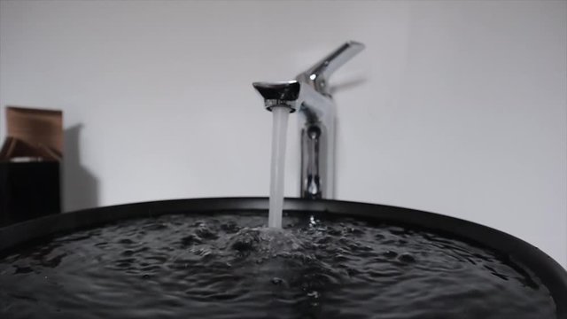 Slow motion running water in bathroom sink