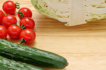 キャベツ、キュウリ、プチトマトが置かれたカッティングボード