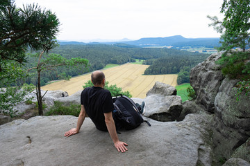 a man admires the open mountains at the top of a mountain