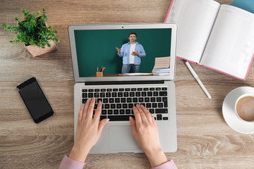 Woman having online video consultation with business trainer at table, top view