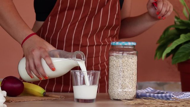 Mujer preparando el desayuno con leche y avena