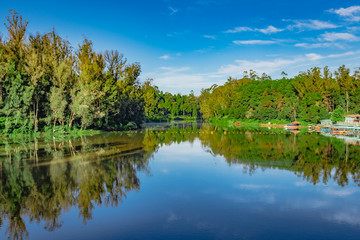 lake pristine with green forest water reflection and bright blue sky at morning