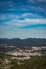 Obraz premium city view with mountain range and bright blue sky from hill top at day