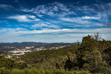 city view with mountain range and bright blue sky from hill top at day