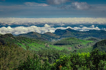 mountain range with cloud layers and green forest