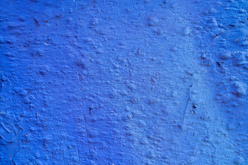 Blue gradient paint on a stucco scratched wall. Close-up of a graffiti texture. Street art background.