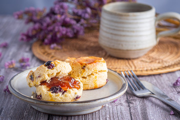 Side view of traditional British scones with a tea cup and blurred background