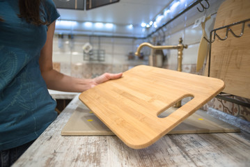 Woman is choosing a new cutting board for kitchen close up.