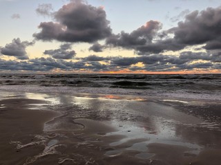 Ciemne chmury nad morską plażą po zachodzie słońca.  © GregStu