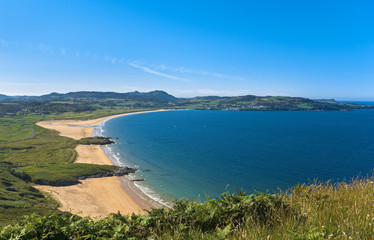Portsalon, Donegal, Ireland, where the golden sands of a deserted beach and the deep blue waters of Lough Swilly, an inlet of the Atlantic Ocean, bask in the sunshine on a hot summer day.