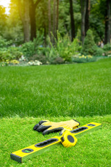 Artificial grass laying background with work tools on a beautiful garden backdrop.