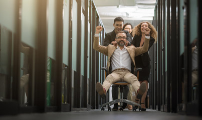 Business team celebrating in office. Successful entrepreneurs and business people achieving goals. Boss sitting on chair and ride along the way.