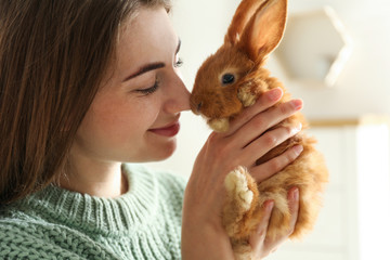 Young woman with adorable rabbit indoors, closeup. Lovely pet - Powered by Adobe
