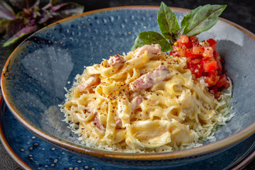 Gourmet delicious tagliatelle carbonara pasta cooked with cheese, egg, bacon and cream sauce. Balanced nutritious dish. Still life for restaurant poster