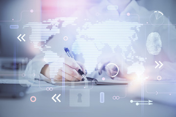Double exposure of hands making notes with world map hologram and data theme icons. Concept of international network data.