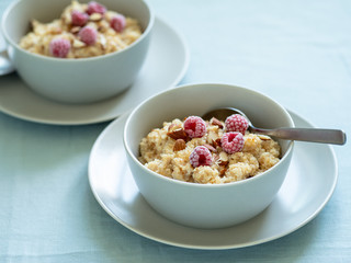 Quinoa porrige on tabletop. Two bowl wit quinoa milk porridge with berries and almond