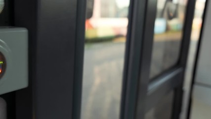 Man presses round button to open automatic door on the bus. COVID-19 public transport as Infection pathway. Stop button on a bus rail. Slow motion 4k