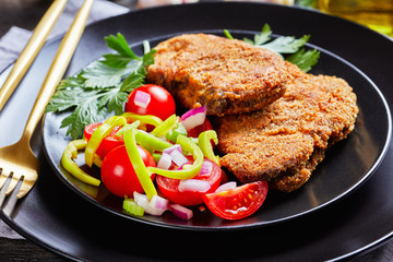 close-up of breaded lamb chops and salad