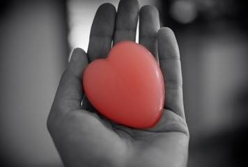 a woman holds in her hand a heart-shaped soap. Heart symbol of love