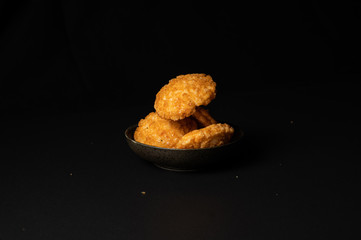 fried crispy rice crackers called rice age with soy,salt sugar etc flavor on black background is a traditional japanese snack.