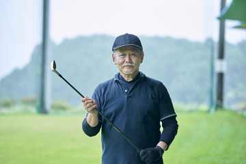 ゴルフ場で練習をするシニアの男性