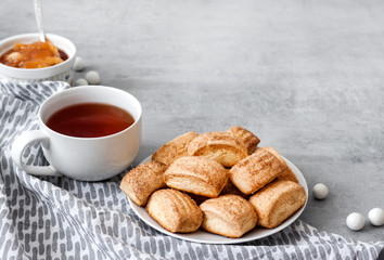Tasty breakfast. Homemade sweet cinnamon cookies and cup of tea. Apple confiture on background