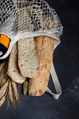 Italian bread baguette stirato and a bottle of wine in a shopping bag