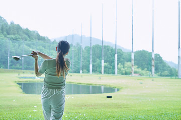 ゴルフ場で練習をする若い女性