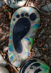 Hand-painted colorful stones. Stone painting. Human foot drawing