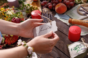 Still life on a wooden table. Lavender seeds, buds and flowers - aromatherapy and herbal medicine. Festive table in nature. Solstice concept. Lettering and Herbal Medicine and Aromatherapy.