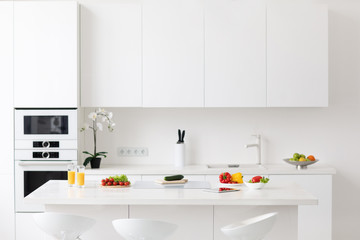 Light kitchen interior with fresh vegetables on the table.