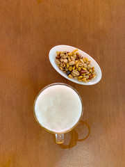 TOP VIEW OF A TANKARD OF BEER AND A DISH OF DRIED FRUIT