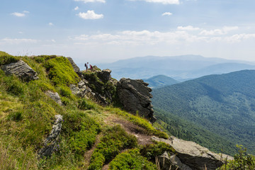 Summer landscape of the Carpathians on a sunny day. The main watershed. Mount Pikuy, Ukraine. Rock ledges on a background of mountains. Landscape with high mountains.