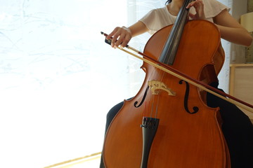 チェロを弾く若い女性　柔らかい光が射す部屋で woman playing the  cello © kesuku