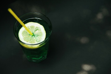 Green coctail on black background. Poison Ivy coctail. Summer drink. 