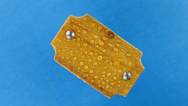 Rotation of a wooden board with water droplets pulsing from the wind. Chroma key