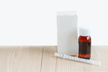 A bottle medicine syrup with a syringe  for kids on the white background with the copy space .