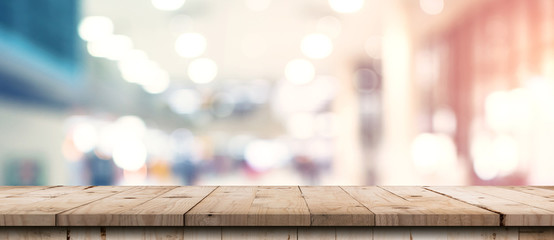 Abstract blurred image of department store with wooden table counter background for show , promote...